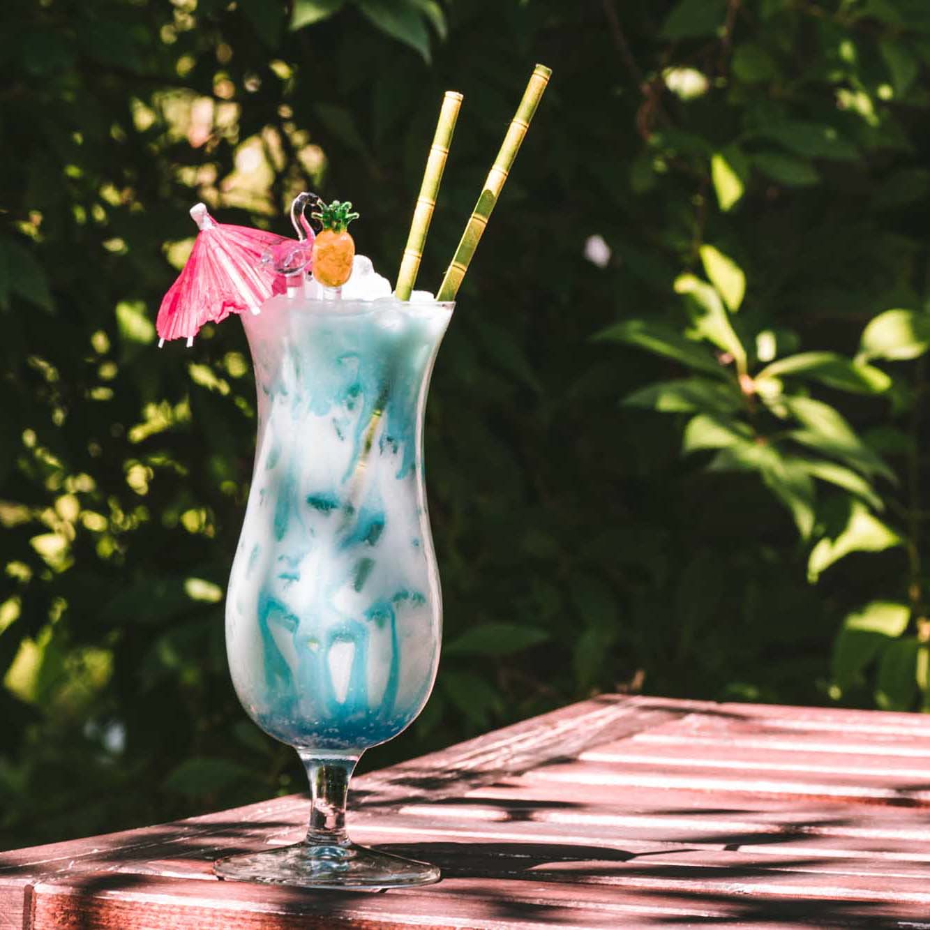 Ein sommerlicher Swimming Pool Cocktail mit Schirmchen und Rühr-Ananas.