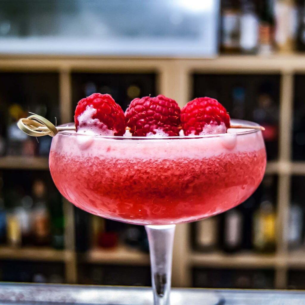 Der Clover Club Cocktail, garniert mit frischen Himbeeren.