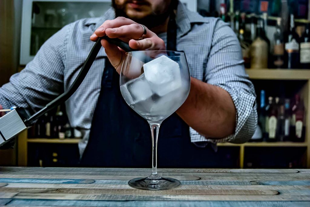 Das Glas wird unter der Kuppel geräuchert, während der Drink im Rührglas wartet