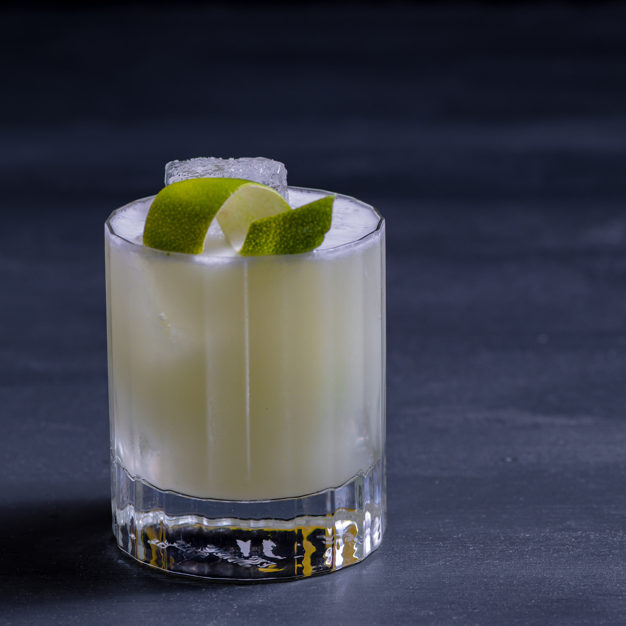 Ein Beuser & Angus Special Cocktail mit Limettenzeste.