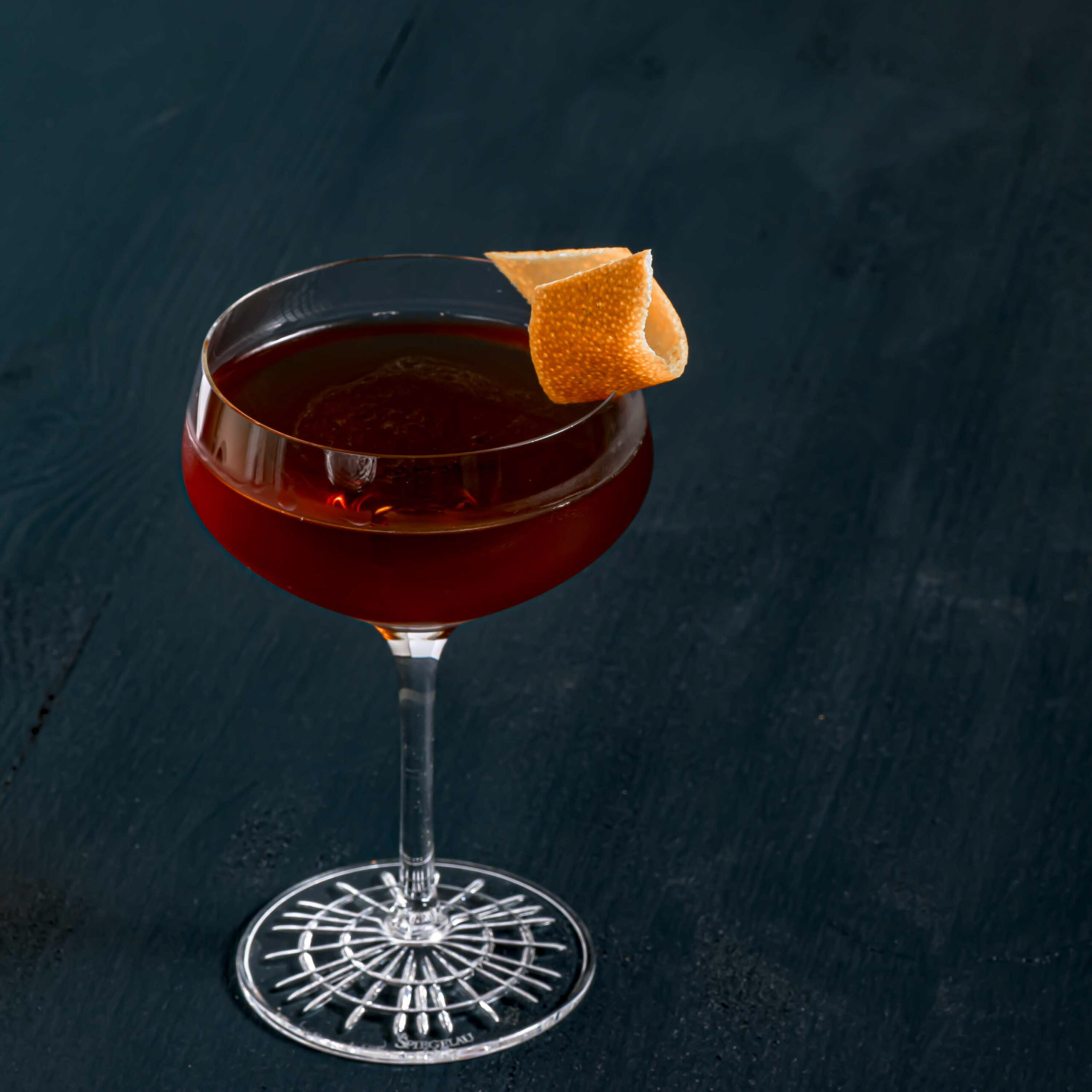 Ein Broadway Nights Cocktail mit Rye Whiskey, Mezcal, Chartreuse Verte, Triple Sec, Chocolate Bitters und süßem Wermut.