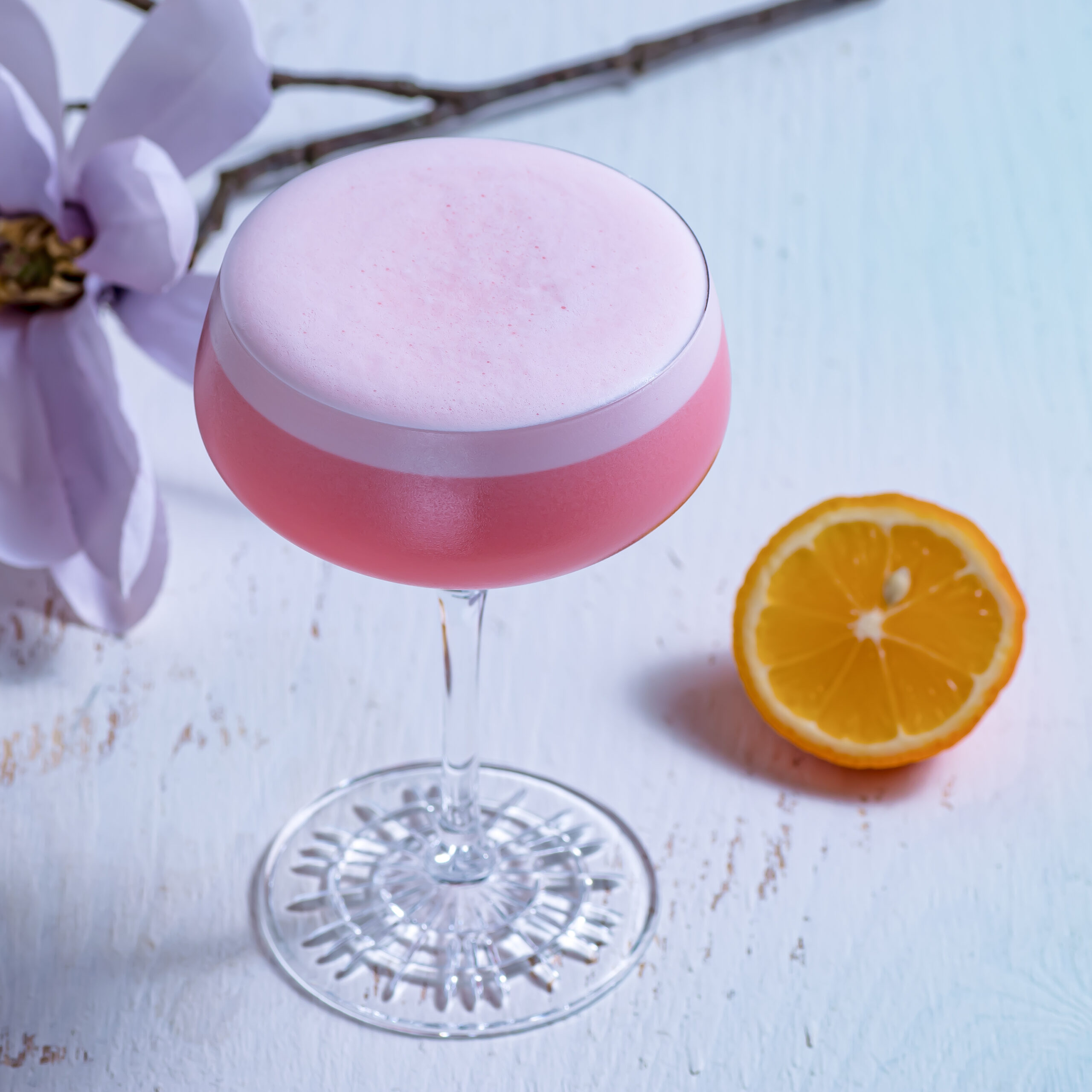 Ein Ruby Chocolate Sour Cocktail mit roter Zitrone.