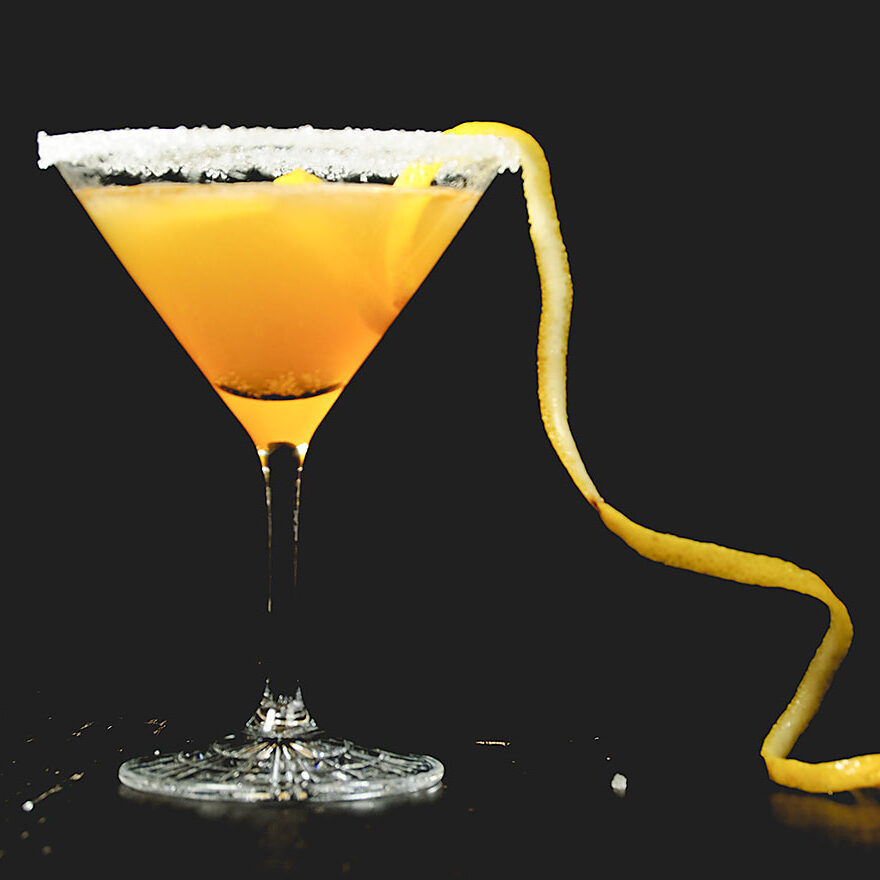Ein Sidecar-Cocktail aus Zitronensaft, Cointreau und Cognac, garniert mit einem Zuckerrand und einer Orangenzeste.