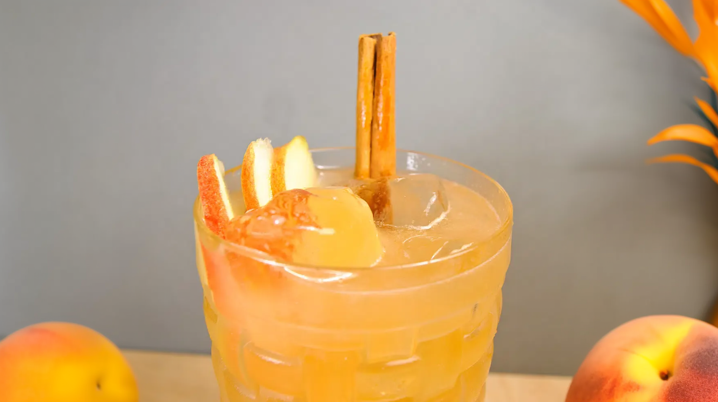 Ein Brazilian Mule aus Cachaca, Apfelsaft, Limettensaft, Vanillelikör und Angostura Bitters, garniert mit Äpfeln und einer Zimtstange.